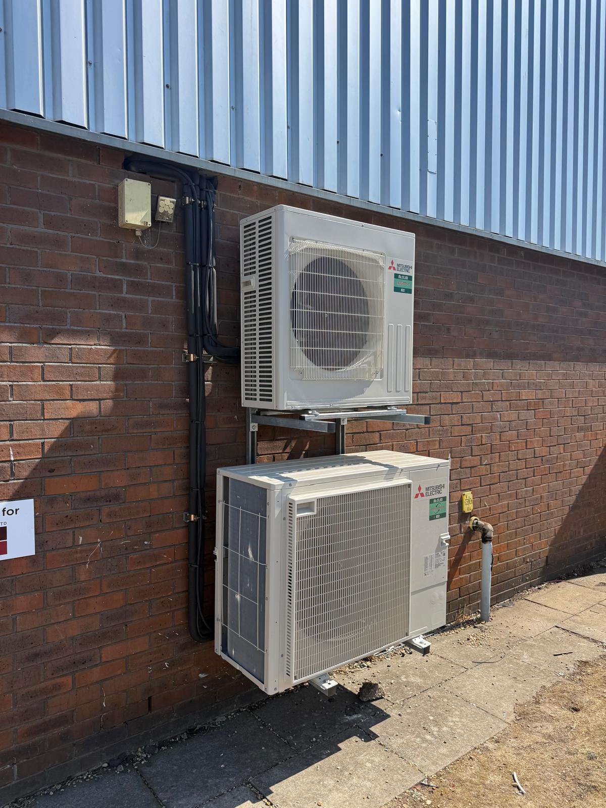 Mitsubishi Electric outdoor units installed on a commercial brick wall